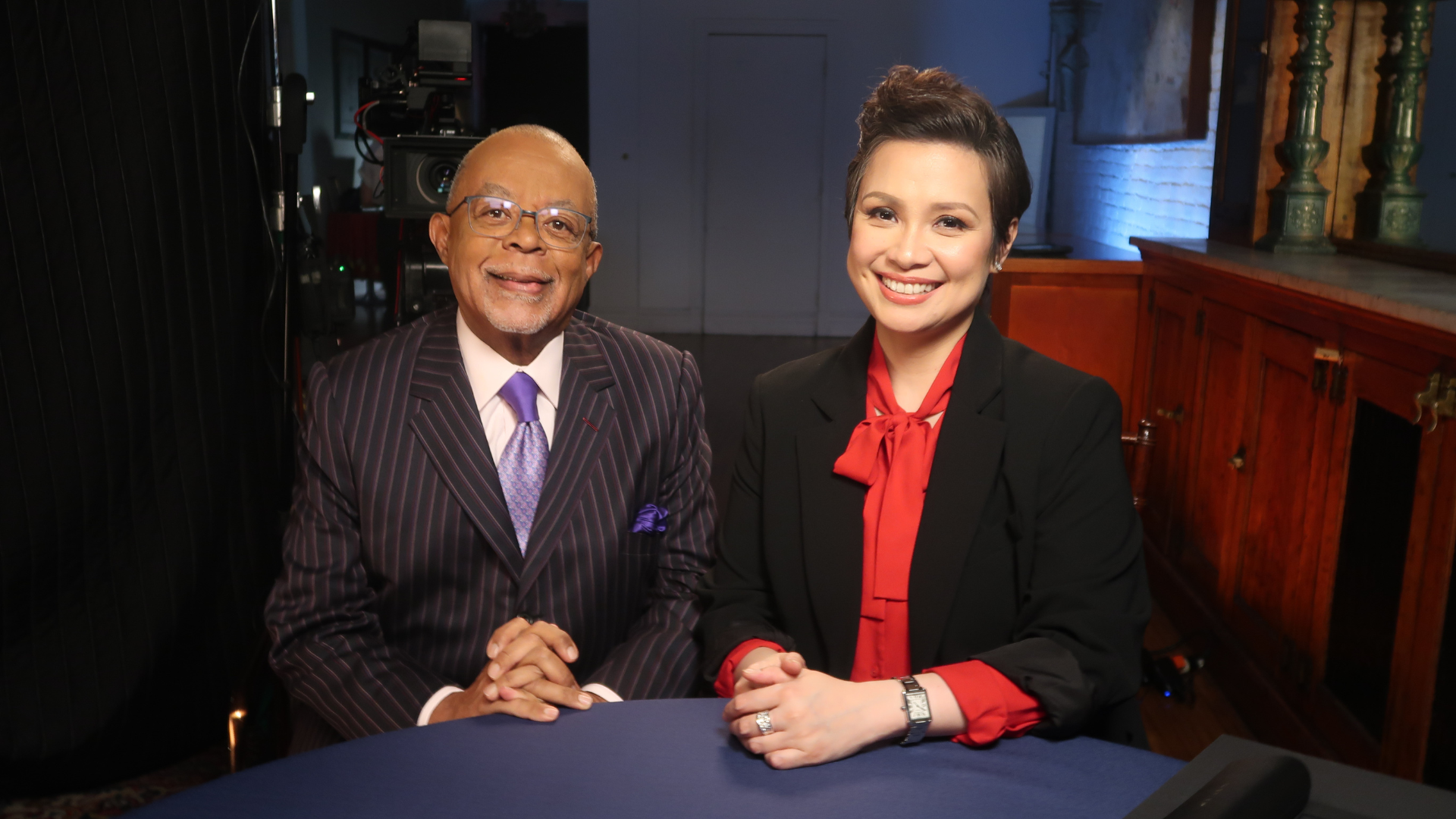 Henry Louis Gates Jr. and Lea Salonga sitting at a table together. 